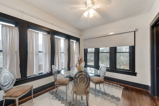 dining space with ceiling fan, wood finished floors, and baseboards
