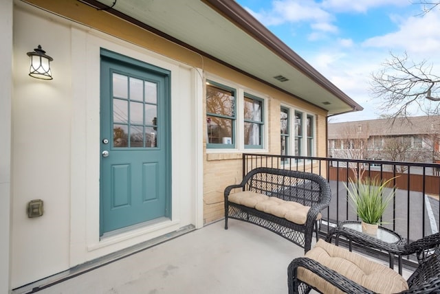 view of exterior entry with a balcony