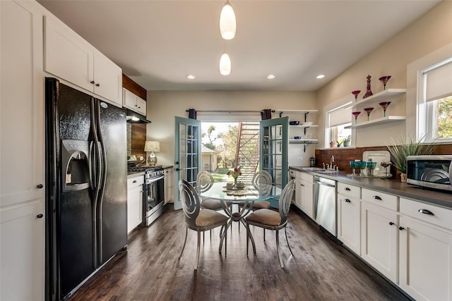 kitchen with stainless steel appliances, open shelves, under cabinet range hood, white cabinets, and dark countertops