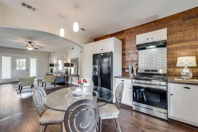 dining area with visible vents, arched walkways, ceiling fan, and dark wood-style flooring