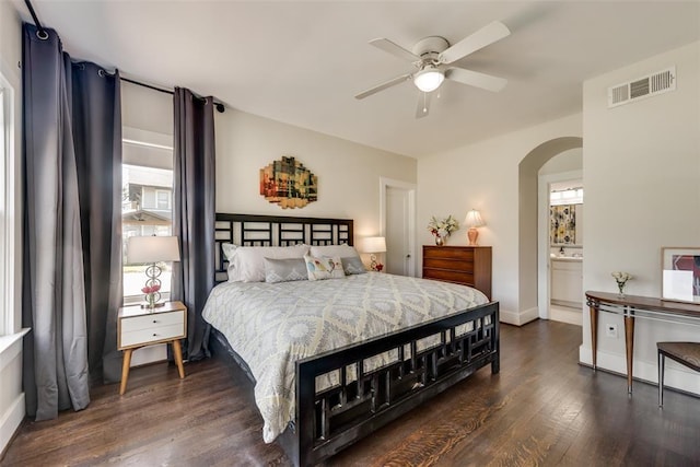 bedroom with dark wood-style floors, ceiling fan, visible vents, baseboards, and arched walkways