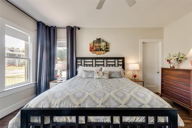 bedroom featuring dark wood finished floors, baseboards, and a ceiling fan