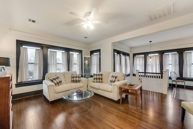 living room with visible vents, ceiling fan, wood finished floors, and baseboards