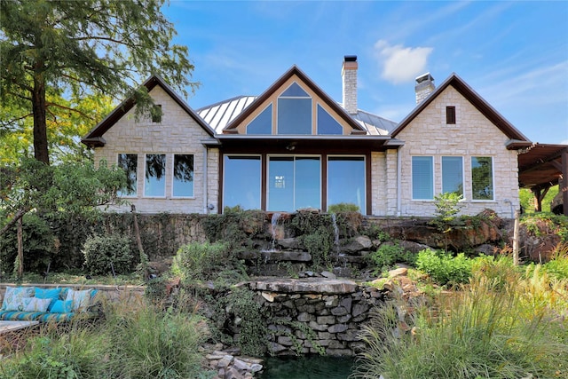 11588 Wild Rose Ln, Anna, TX 75409 - back of house with metal roof, a standing seam roof, stone siding, and a chimney