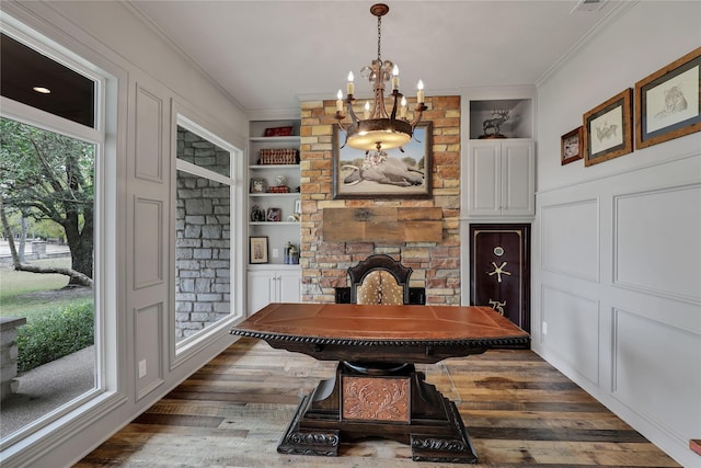11588 Wild Rose Ln, Anna, TX 75409 - dining space with wood finished floors, a chandelier, built in features, ornamental molding, and a brick fireplace