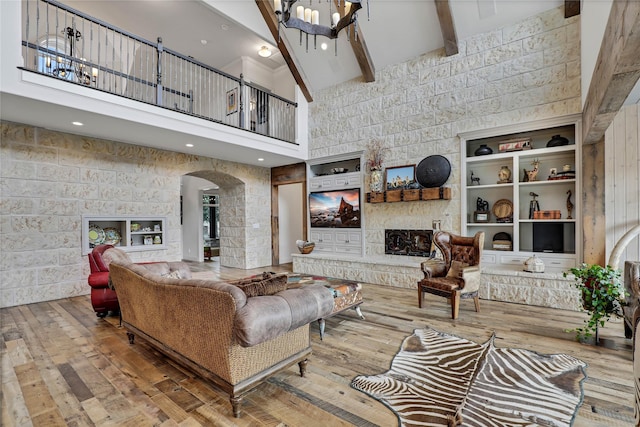 11588 Wild Rose Ln, Anna, TX 75409 - living area with beamed ceiling, a chandelier, wood-type flooring, arched walkways, and a towering ceiling