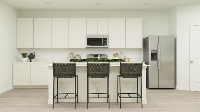 457 Ridge Dr, Justin, TX 76247 - kitchen with a breakfast bar, stainless steel appliances, and light wood-type flooring