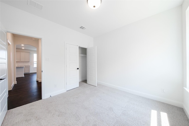 7306 Mallow Way, Venus, TX 76084 - unfurnished bedroom with carpet, arched walkways, baseboards, and a closet