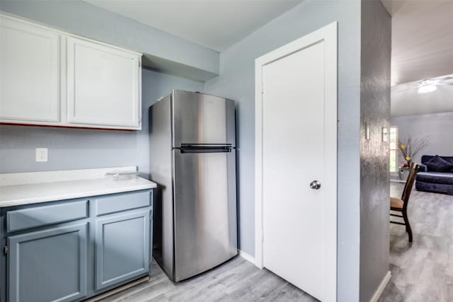 kitchen with light countertops, light wood finished floors, and freestanding refrigerator