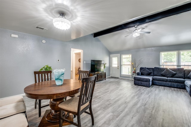 dining room featuring light wood-style flooring, visible vents, lofted ceiling with beams, baseboards, and ceiling fan with notable chandelier