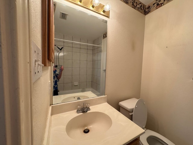 full bath featuring walk in shower, toilet, a textured wall, vanity, and visible vents