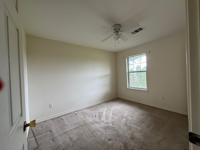 unfurnished room with carpet, visible vents, ceiling fan, and baseboards