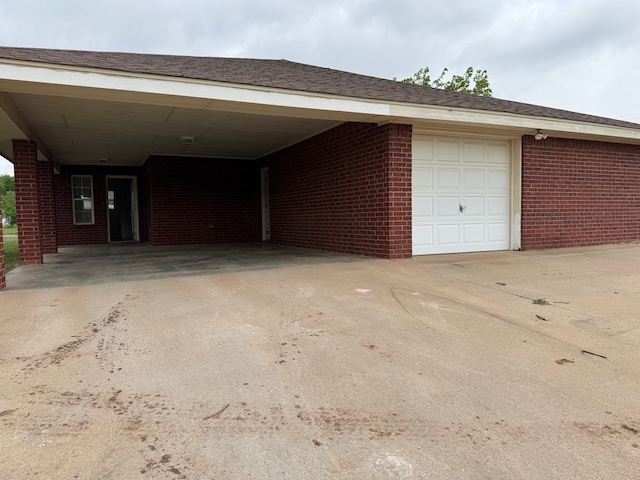 exterior space featuring concrete driveway and an attached carport