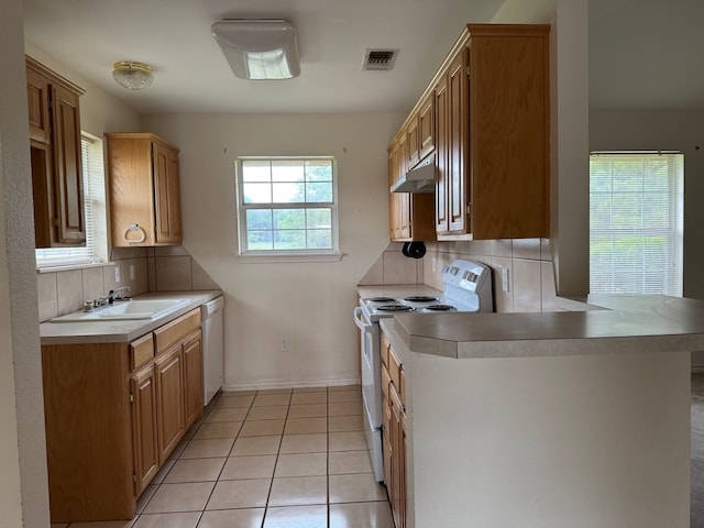kitchen with a sink, under cabinet range hood, tasteful backsplash, visible vents, and white appliances