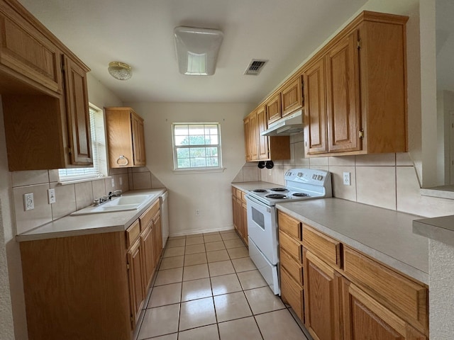kitchen featuring tasteful backsplash, under cabinet range hood, white range with electric stovetop, a sink, and visible vents