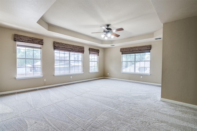 942 Lexington Dr, Rockwall, TX 75087 - carpeted empty room with ceiling fan, a raised ceiling, visible vents, baseboards, and a textured ceiling