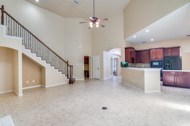 942 Lexington Dr, Rockwall, TX 75087 - kitchen featuring arched walkways, ceiling fan, black appliances, and a towering ceiling