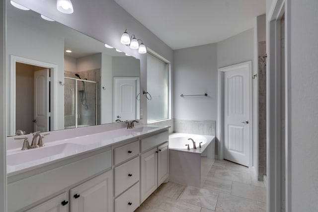 bathroom with a stall shower, a garden tub, double vanity, and a sink