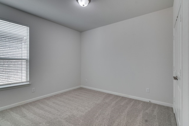 carpeted empty room with baseboards