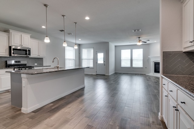kitchen featuring recessed lighting, appliances with stainless steel finishes, a sink, a ceiling fan, and open floor plan
