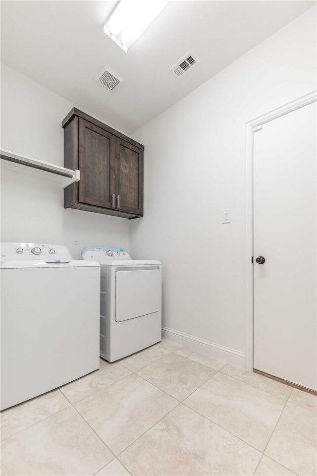 10169 Budtime Ln, Dallas, TX 75217 - laundry area featuring cabinet space, light tile patterned flooring, visible vents, and washing machine and dryer