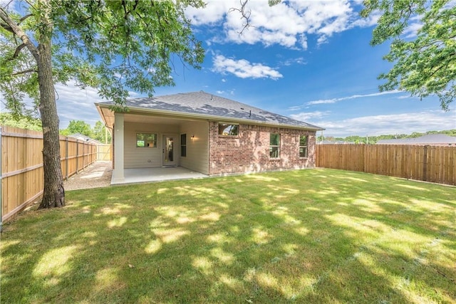 10169 Budtime Ln, Dallas, TX 75217 - back of property featuring brick siding, a fenced backyard, a patio area, and a lawn