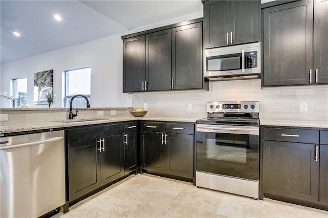 10169 Budtime Ln, Dallas, TX 75217 - kitchen featuring light stone countertops, recessed lighting, a sink, backsplash, and stainless steel appliances