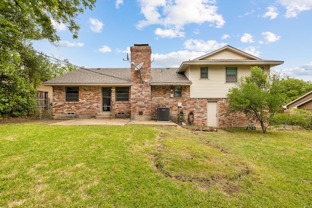 rear view of house featuring a lawn, a chimney, a patio, and brick siding
