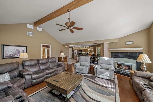 living area with visible vents, wood finished floors, and a ceiling fan
