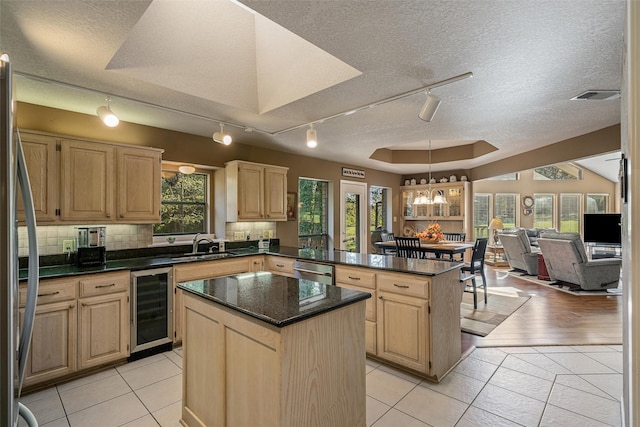 kitchen with wine cooler, light brown cabinetry, rail lighting, and a peninsula