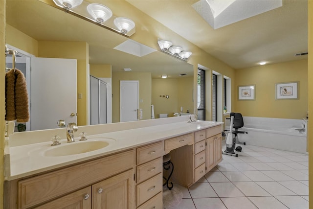 full bath featuring a sink, tile patterned floors, double vanity, a garden tub, and a skylight