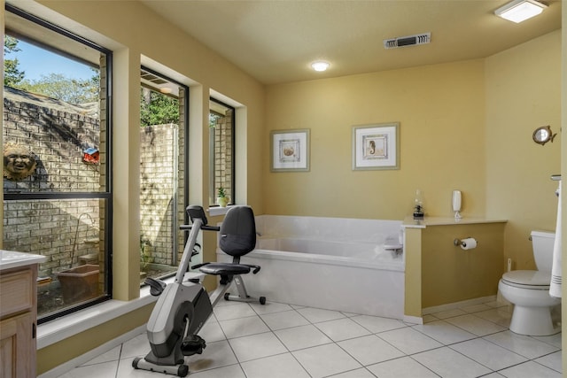 bathroom featuring vanity, a bath, tile patterned floors, toilet, and visible vents