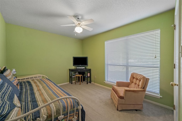 carpeted bedroom featuring a textured ceiling, ceiling fan, and baseboards