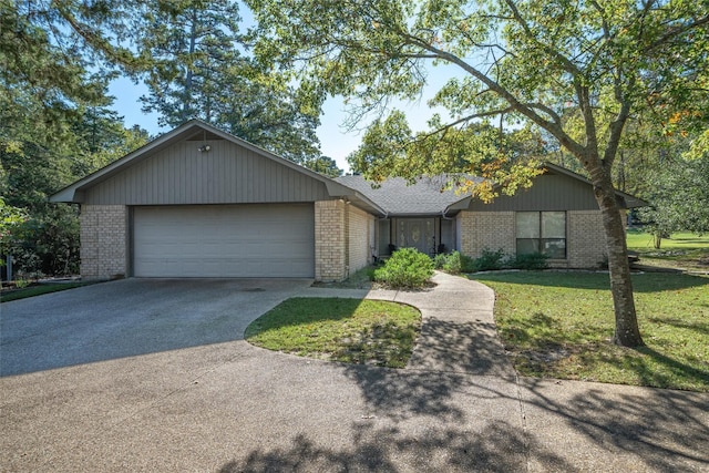 single story home featuring a front lawn, driveway, an attached garage, and brick siding