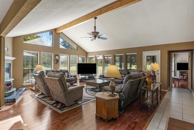 living area featuring beam ceiling, wood-type flooring, ceiling fan, high vaulted ceiling, and a textured ceiling