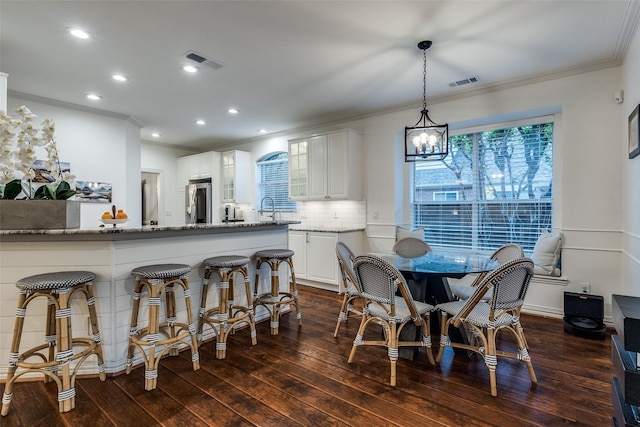 dining area featuring visible vents, crown molding, dark wood finished floors, and recessed lighting