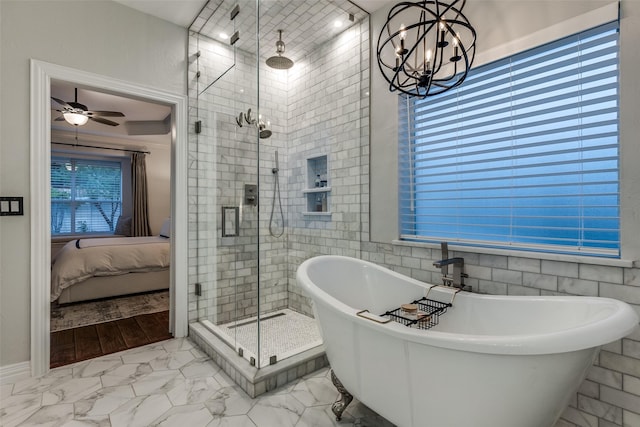 ensuite bathroom with a shower stall, marble finish floor, ensuite bathroom, a soaking tub, and ceiling fan with notable chandelier
