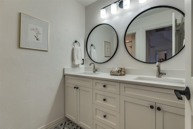 full bathroom featuring double vanity, a sink, and baseboards