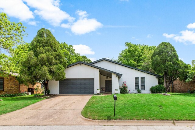 2409 Leslie St, Denton, TX 76205 - view of front of home with concrete driveway, an attached garage, and a front yard