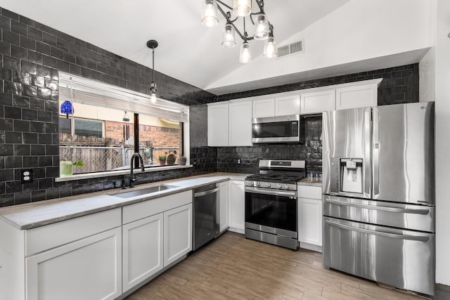 2409 Leslie St, Denton, TX 76205 - kitchen with visible vents, decorative backsplash, a sink, appliances with stainless steel finishes, and vaulted ceiling