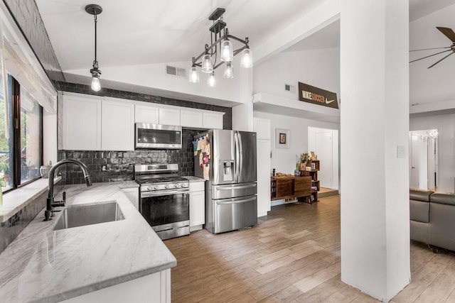 2409 Leslie St, Denton, TX 76205 - kitchen with a sink, stainless steel appliances, white cabinetry, tasteful backsplash, and visible vents