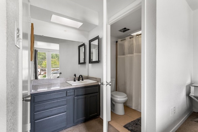 2409 Leslie St, Denton, TX 76205 - full bath featuring vanity, toilet, tile patterned floors, a skylight, and visible vents