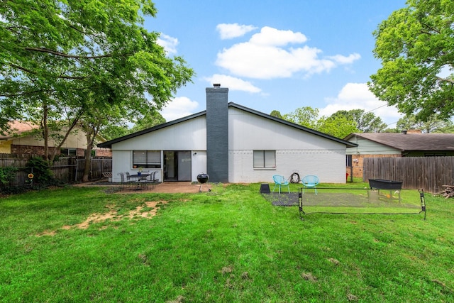 2409 Leslie St, Denton, TX 76205 - rear view of property with a lawn, a chimney, a fenced backyard, and a patio area