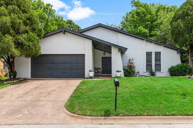 2409 Leslie St, Denton, TX 76205 - view of front facade featuring an attached garage, a front yard, driveway, and brick siding