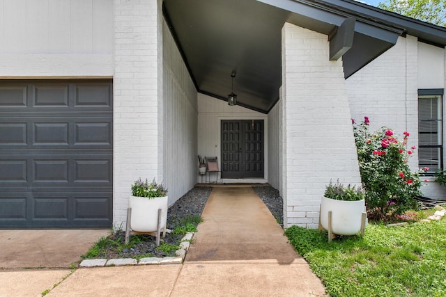 2409 Leslie St, Denton, TX 76205 - view of exterior entry with an attached garage and brick siding