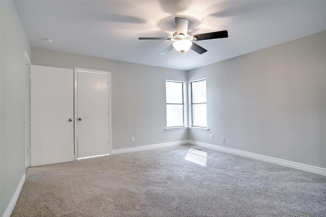 spare room with a ceiling fan, carpet flooring, and baseboards