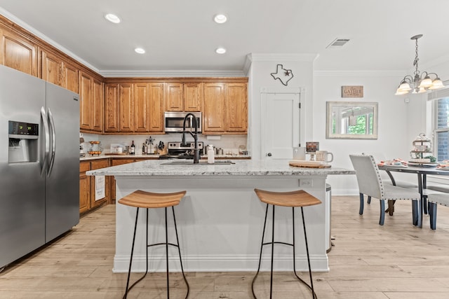 kitchen with crown molding, visible vents, stainless steel appliances, an inviting chandelier, and a kitchen bar