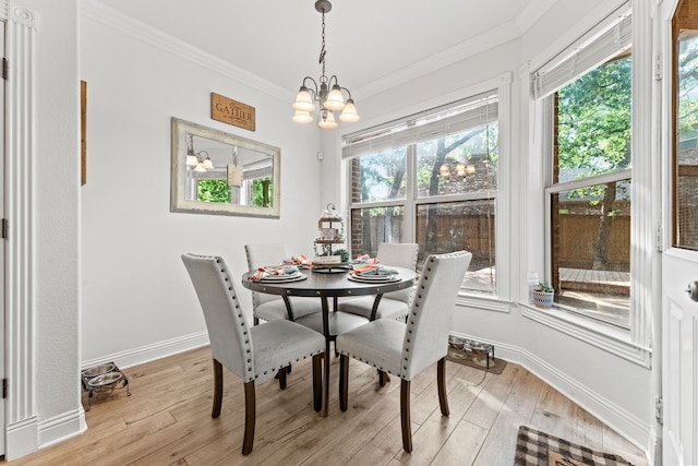 dining room featuring ornamental molding, light wood-style flooring, and a chandelier