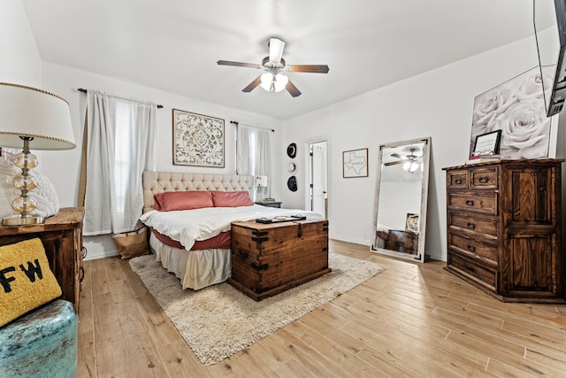 bedroom featuring light wood finished floors, ceiling fan, and baseboards