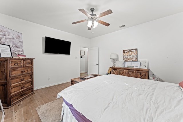 bedroom with baseboards, visible vents, a ceiling fan, and light wood-type flooring